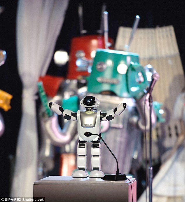 A closer shot shows the adorable robot with its arms in the air as a larger green robot dances in the background