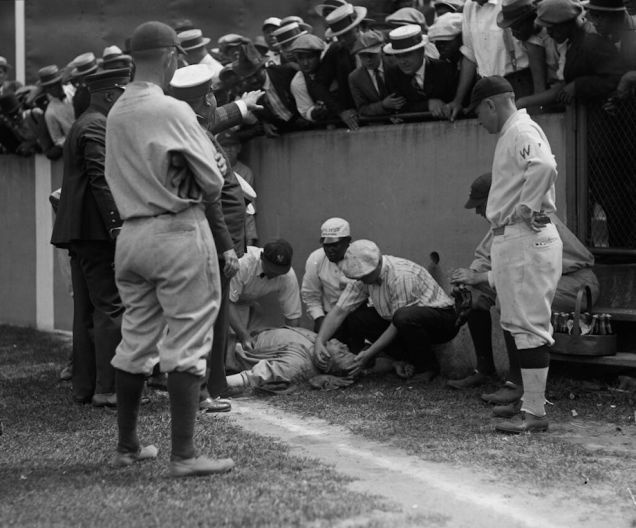 Babe Ruth lying unconscious after running into a wall while chasing a fly ball. He regained consciousness five minutes later - and got two more hits in the game. 