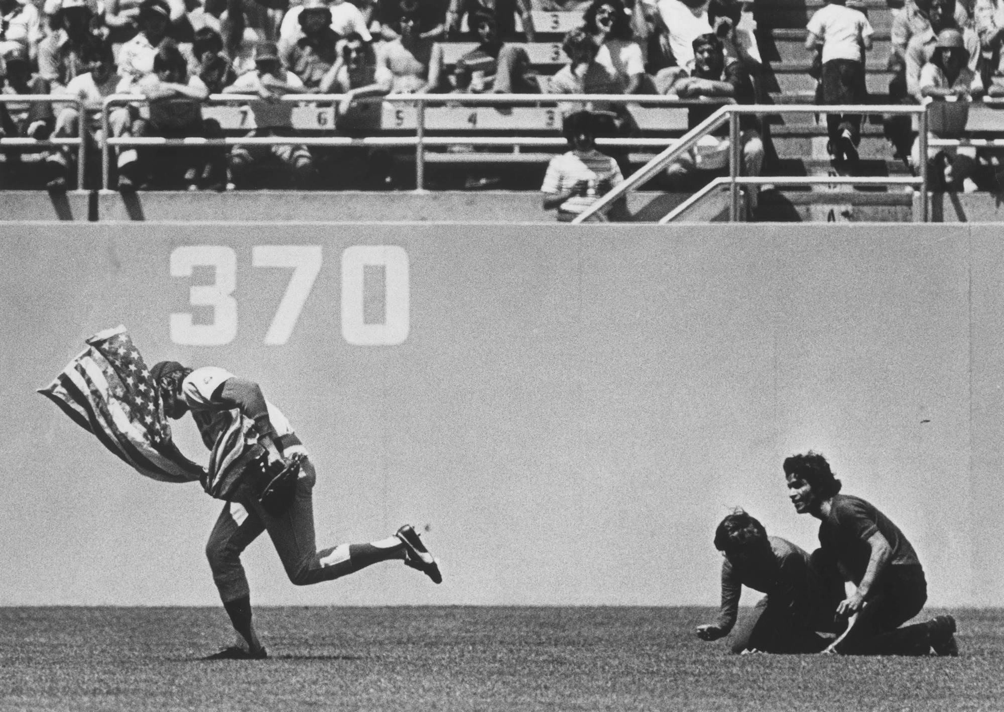 Chicago Cubs centerfielder Rick Monday, saving the American flag from being burned by protesters.