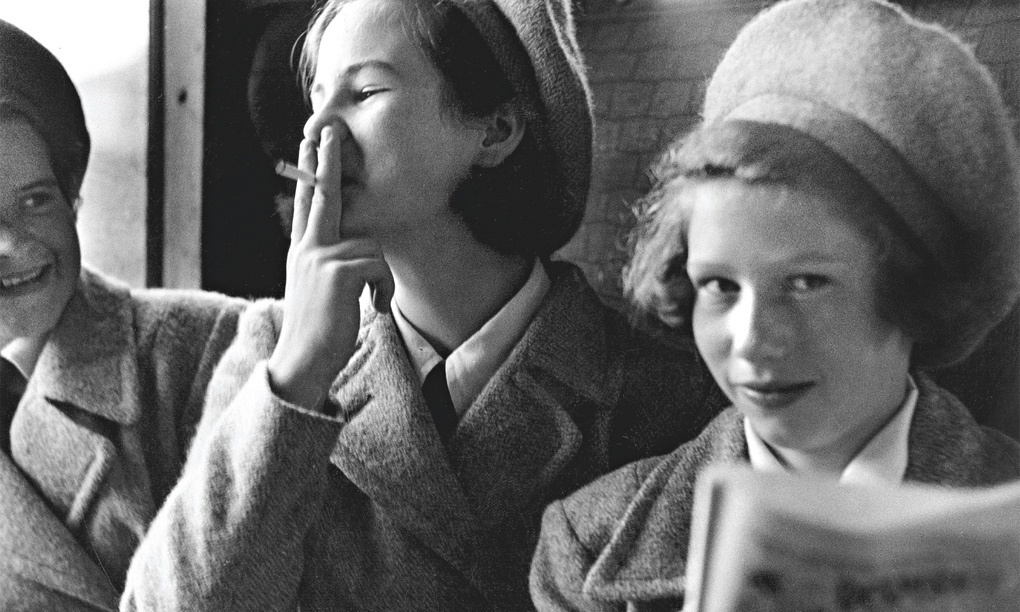 Teenage girls experimenting with cigarettes on train taking them to school.