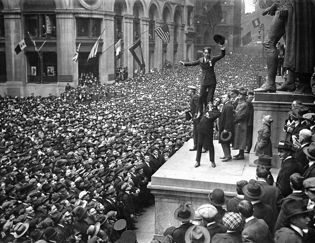 Douglas Fairbanks holding up a triumphant-looking Charlie Chaplin in the middle of New York City.
