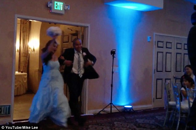 Making an entrance: The bride and groom dance their way into the room filled with guests