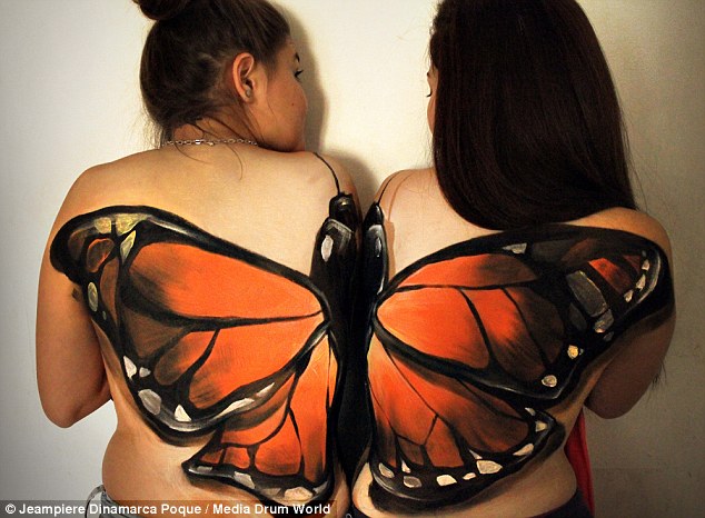 A giant orange butterfly appears to have landed on the back of two models thanks to Jeampiere's clever, mind-altering trickery 