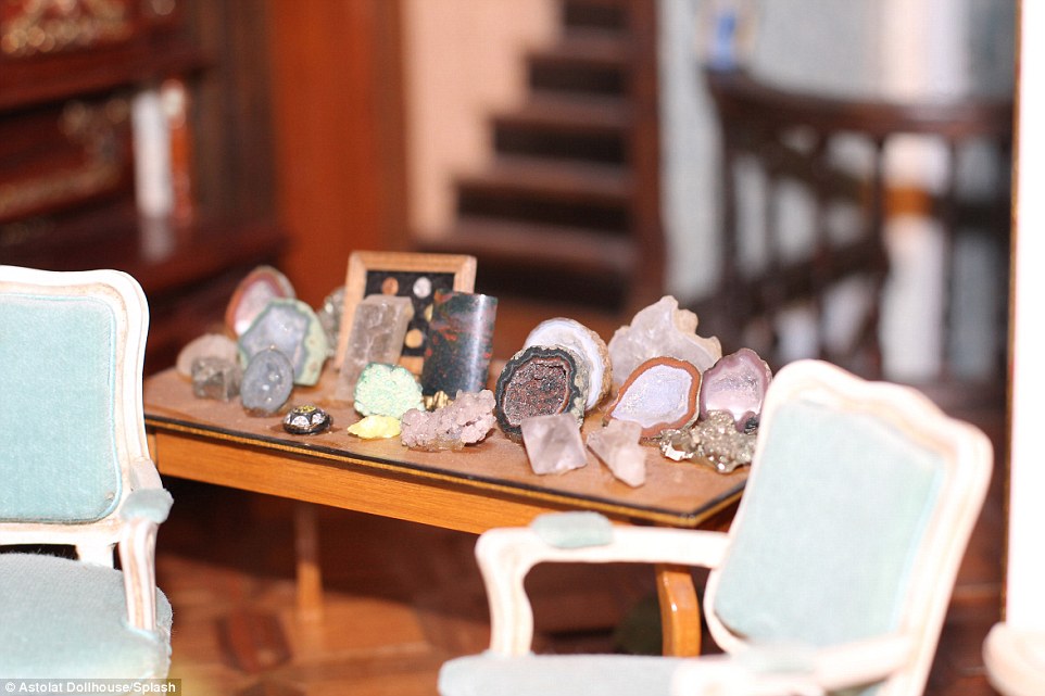 Real crystals line this desk, and at the back there is a miniature frame with a selection of tiny stones inside 