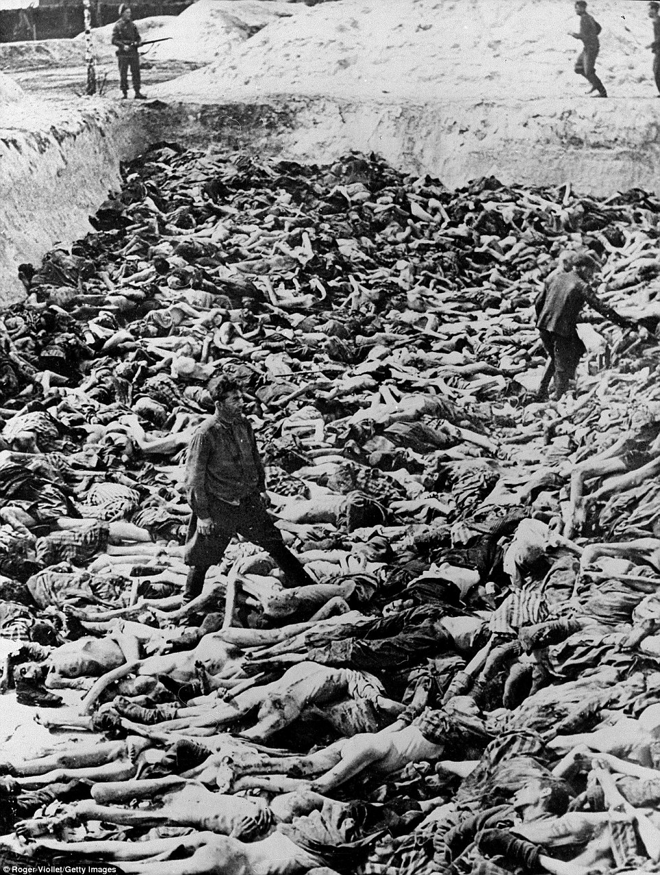 April 1945: Fritz Klein, a Nazi camp doctor who conducted medical experiments on prisoners during the Holocaust, stands among corpses in a mass grave after the liberation of Bergen-Belsen, Germany. Of the 38,500 inmates found barely alive after liberation, about 28,000 subsequently died. Watched by British soldiers, Klein is pictured here being forced to bury the dead. That December, he was sentenced to death and hanged for his role in the atrocities. Bergen-Belsen was the first Nazi camp to be liberated - and gave the world some of the first visual evidence of the horrors of the Holocaust