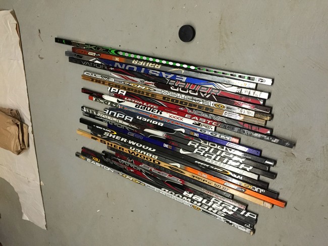 First, he gathered and arranged the hockey sticks.