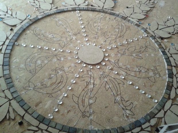 The center design has a fish pattern. The "water" effect would be created using glass stones.