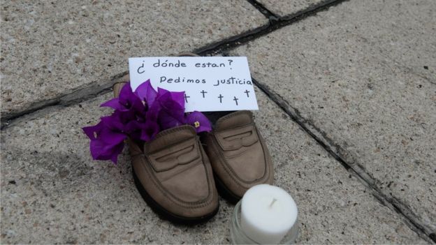 A pair of girl's shoes with flowers, a message that reads 'Where are they? We ask for justice' and a candle, placed by relatives of missing people at El Angel square on July 10, 2011 in Mexico City