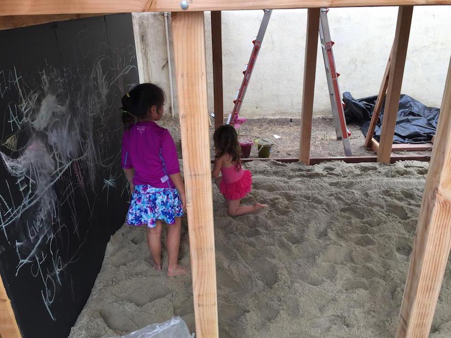 "I built them a sand box below the deck using 50 bags of sand. I also placed a pressure treated 2x6 all the way around the bottom and used two 1/2" bolts at every connection. It was now crazy strong. You can also see the chalkboard at the back which I made using hardie tile backer board and screwing to the studs and painting it with a flat black exterior latex paint."