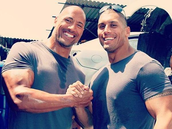 As The Rock lands more and more roles in major motion pictures, he's got to make sure he stays out of harm's way. That's why he has a stand-in double when scenes get a bit too dangerous. But, instead of some random guy standing in for him, his cousin Tanoai Reed has assumed the role. What do you think, do they look alike?