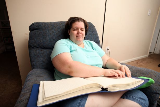 Jewel Shuping reading Braille at home on August 12, 2015 in Raleigh, North Carolina.