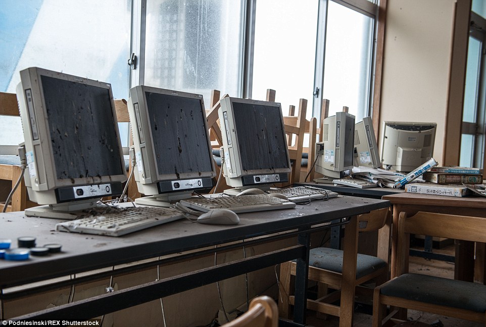 Computer screens left covered in waste and animal droppings lie untouched inside a classroom in one of the villages near Fukushima