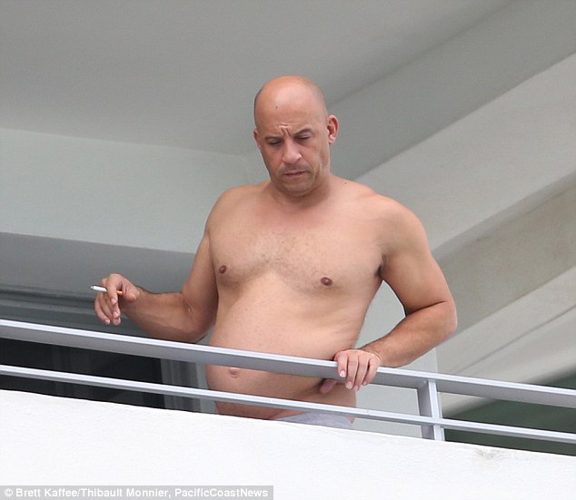 Enjoying a cheeky smoke: Vin Diesel took his shirt off while basking in the Florida humidity on the balcony of the Shore Club, showcasing his famous physique, on Tuesday