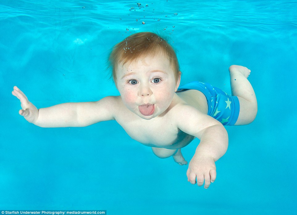 Ethan, 10 months old, at an underwater photoshoot with Aquatots Swim School in Gloucestershire, cheekily sticks his tongue out as Lucy captures him in the swimming pool