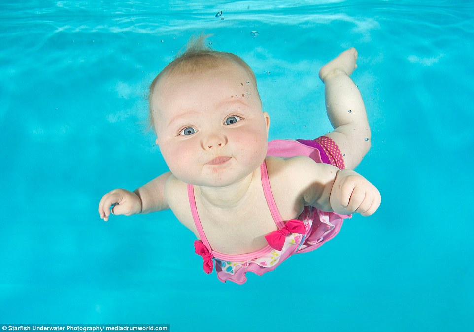 Lilly-May, who is eight months old, holds her breath as she is captured at an underwater photoshoot with Aquatots Swim School in Gloucestershire