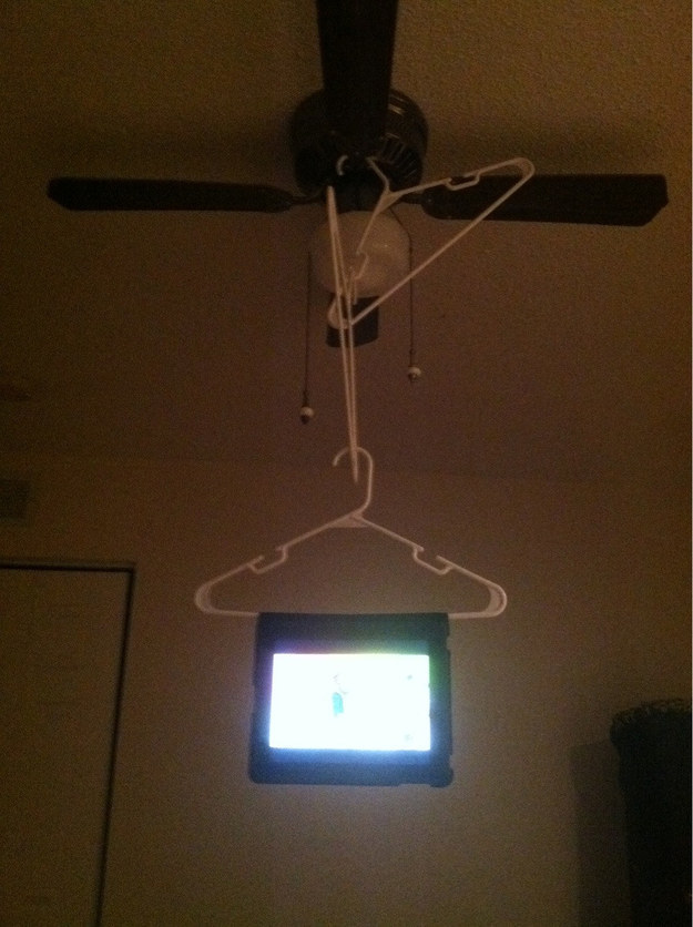 Fed up of having to hold your iPad while watching a movie? Hang that thing from the ceiling fan with some clothes hangers.