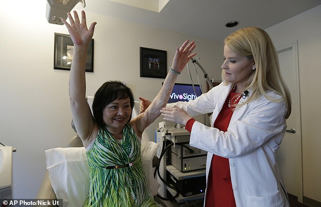 Dr. Jill Waibel (right) of Miami Dermatology and Laser Institute examines Kim Phuc (left) before the first of several laser treatments to reduce pain and the appearance of burn scars in her back and left arm.