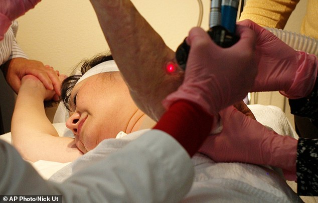 Dr. Jill Waibel applies a laser to the arm of Kim Phuc to reduce the pain and appearance of her burn scars in Miami. Phuc was burned in the back and left arm by a napalm bomb in Vietnam over 40 years ago.