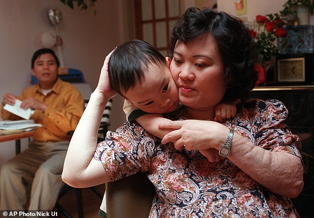 Here, in 1997, Kim Phuc holds her son Thomas, 3, in their apartment in Toronto. Her husband, Bui Huy Toan, is at left.