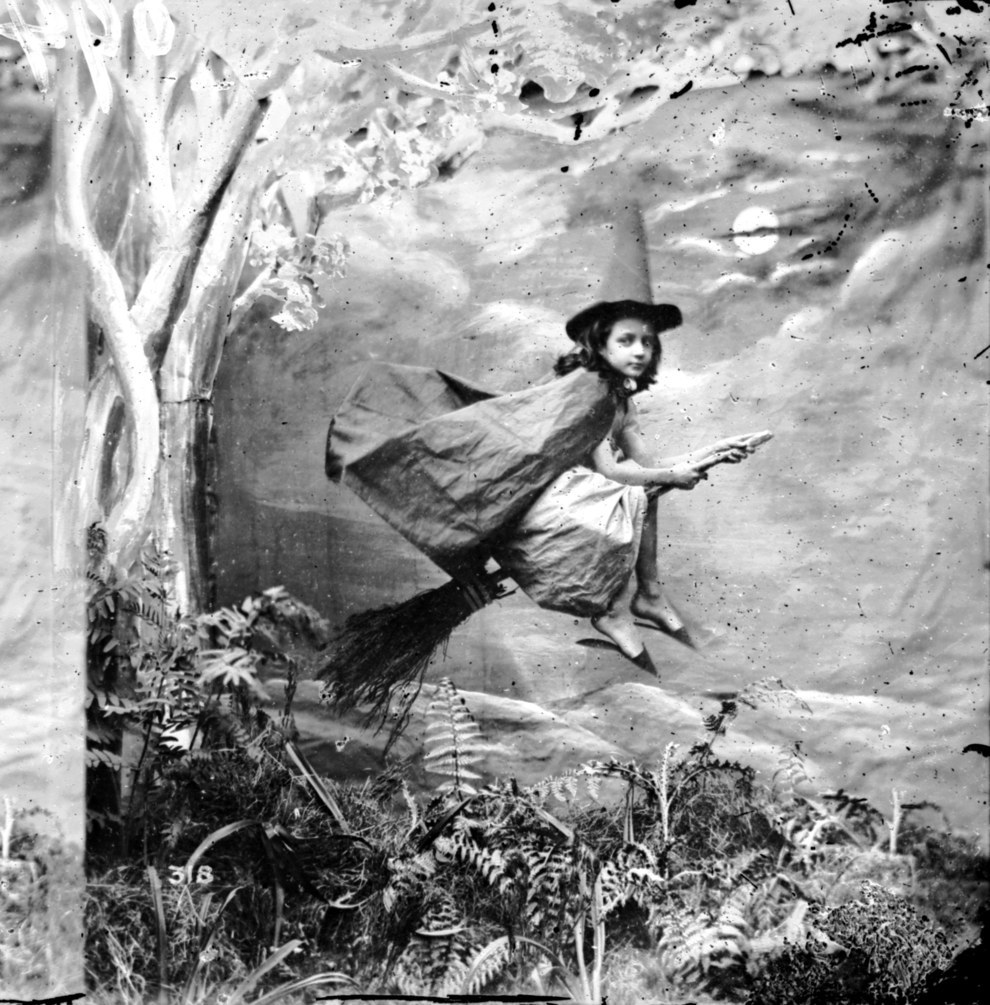 This little witch on her broomstick, circa 1865.