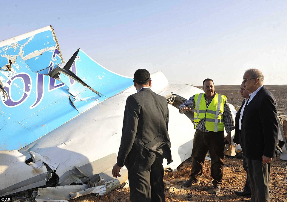 Remains: This evening, the prime minister's office said: 'The black box was recovered from the tail of the plane and has been sent to be analysed by experts.' Above, Mr Ismail (far right, in a black suit) is seen looking at the remains of the crashed passenger jet in Hassana