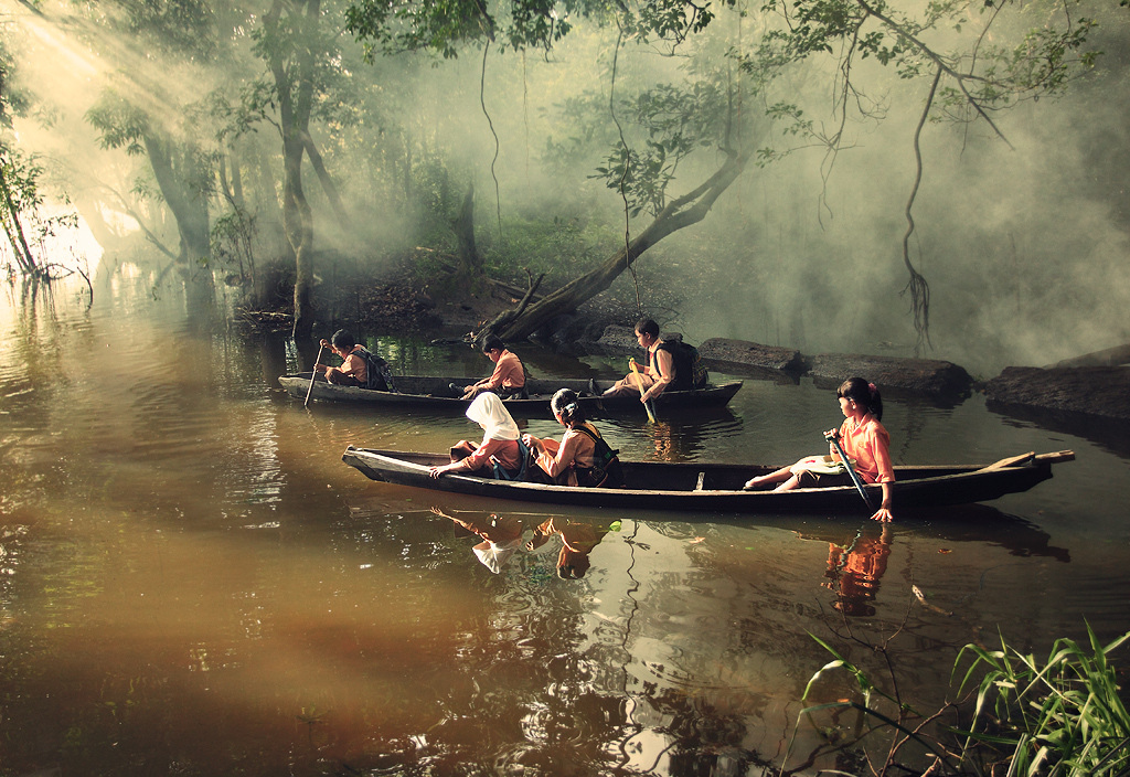 Kids canoeing to school in Riau, Indonesia.