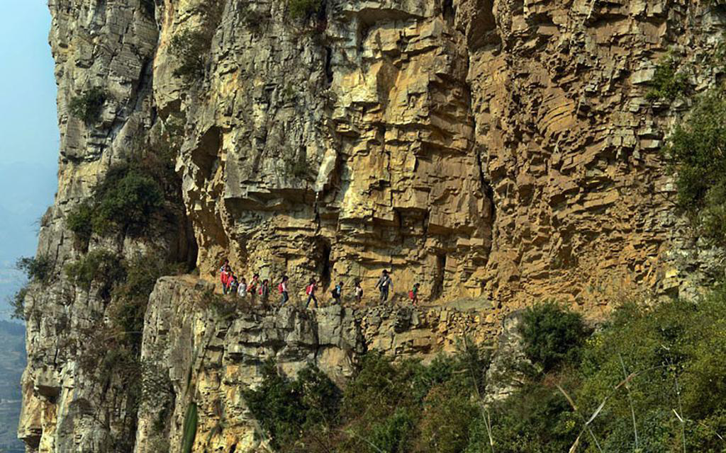 Students take a 5-hour journey into the mountains on a 1 foot wide path to probably the most remote school in world, in Gulu, China.