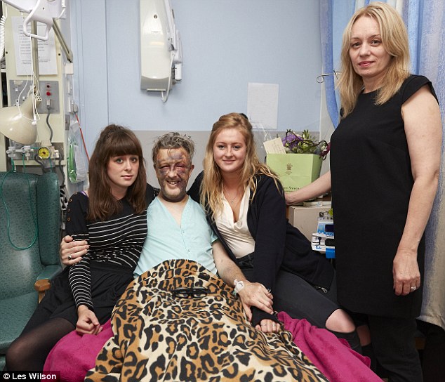 Proud: Paul clings to two of his four daughters at his hospital bedside while his wife Sam stands by them