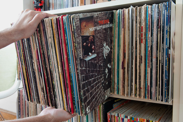 Cover the sides and front of a box with album records to create a hidden storage compartment in your music shelf. 