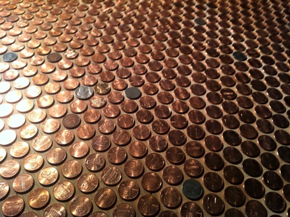 After they're done, they'll use black grout to make the pennies really pop.