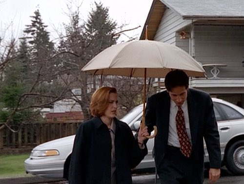 Walking alongside a short person holding an umbrella: