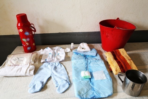 Marie Lucette from Madagascar brought gauze, cotton baby clothes, and a sheet. Plates, spoons, cooking pot, and a chicken to cook for soup are also items the family brought. 