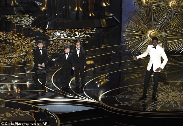 Rock invited three young Asian children (pictured) on to the stage at the Oscars and introduced them as 'PricewaterhouseCoopers accountants'
