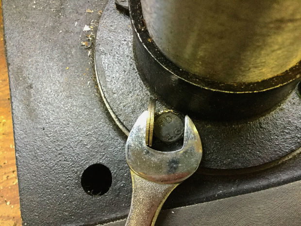 Use the change to fill in the gap between the wrench and screw.