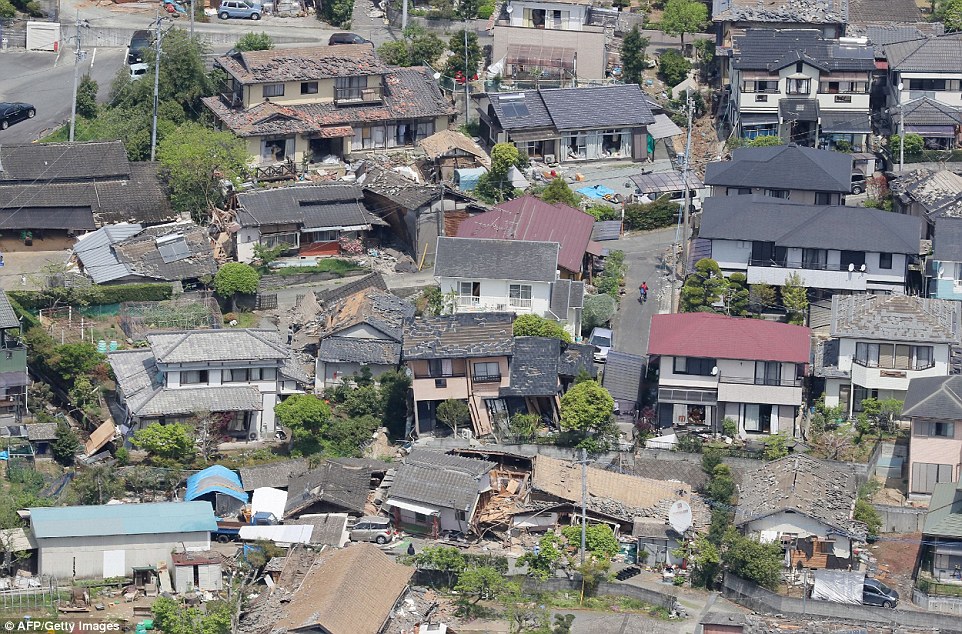 Devastation: On the streets, the remains of collapsed Japanese-style houses - many of them aged, wooden structures - could be seen, and damaged roof tiles lay in piles