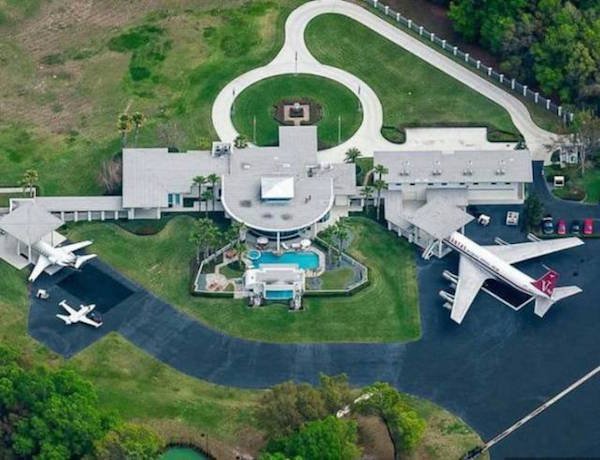 The ‘Jett-Bleu’ estate, named after John Travolta’s children, is located in Central Florida, and it's kind of badass. Not only does the 6,400 sq. foot abode boast a 16-car garage, a gym, a mini-golf course and a guest home, it also has airplane hangers. Yep. Plural. HANGARS.

His house has more runways than driveways. Let that sink in. I mean, it makes sense, as Travolta is an aviation fanatic and owns five planes, but wow. Even more awesome (yet still somehow infuriating?) is that the runways lead directly to his front door and are large enough to bring in a 707. 

Not bad for a guy who played a fallen angel.