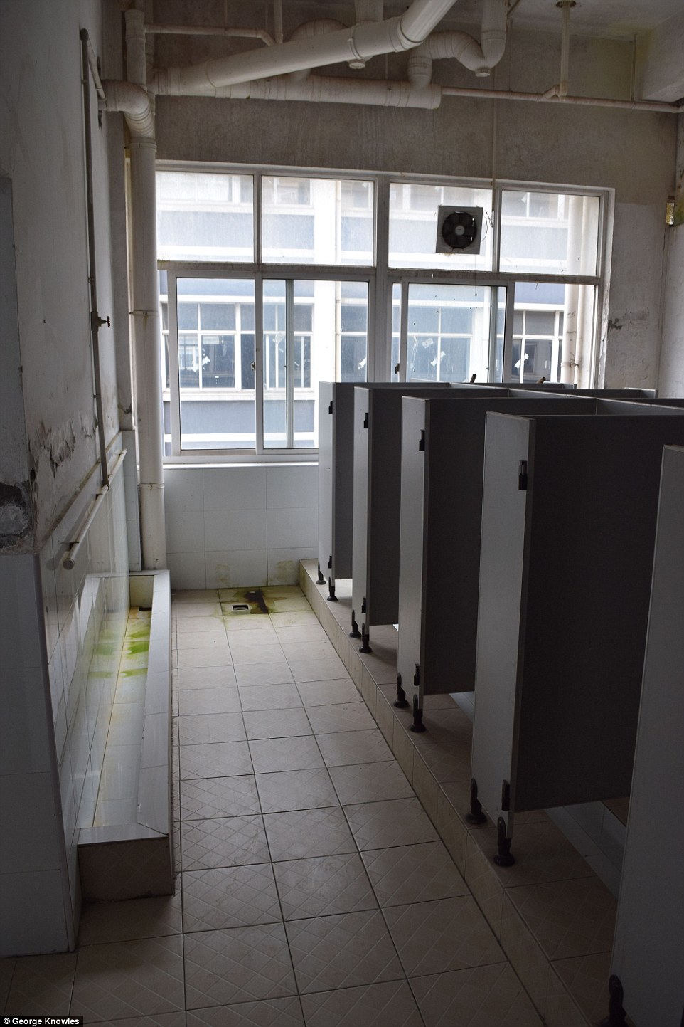 Filthy: These exclusive images show the sanitary facilities at a dormitory where workers who create Apple iPhones live, washing in mildewed sinks and squatting over open sewers to go to the toilet 