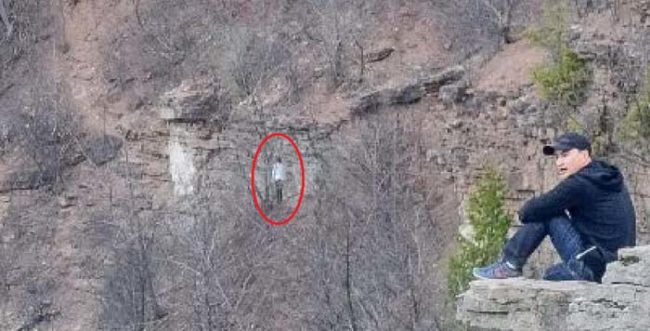It appears to be some sort of unnaturally tall, ghostly figure. According to SlicedUpBeef, they thought it could have been a hiker, except that the area is not part of the trail and it's so steep that'd be almost impossible to traverse.