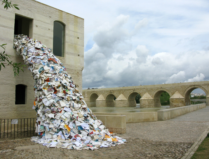 Thousands of paperback books falling out of a window.