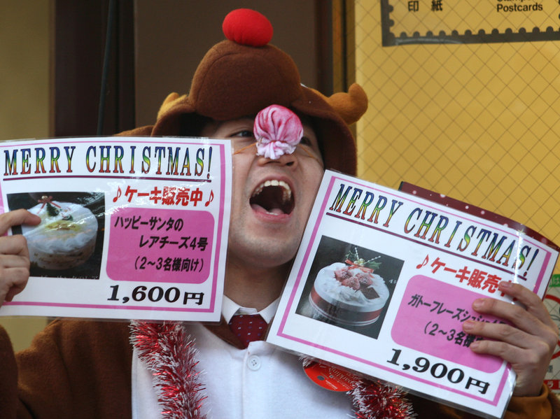 A man in a reindeer costume hawks Christmas cake outside a bakery in Kobe, Japan, Dec. 23, 2011.