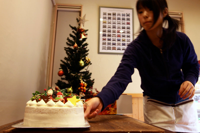 A woman prepares a Japanese Christmas cake at the Patisserie Akira Cake shop on Dec. 23, 2011. The sponge cake is drenched in symbolic meaning.