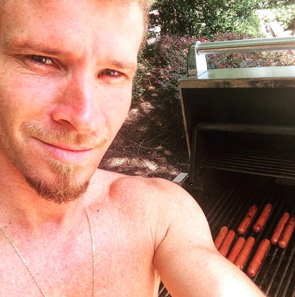 He grills hot dogs shirtless.