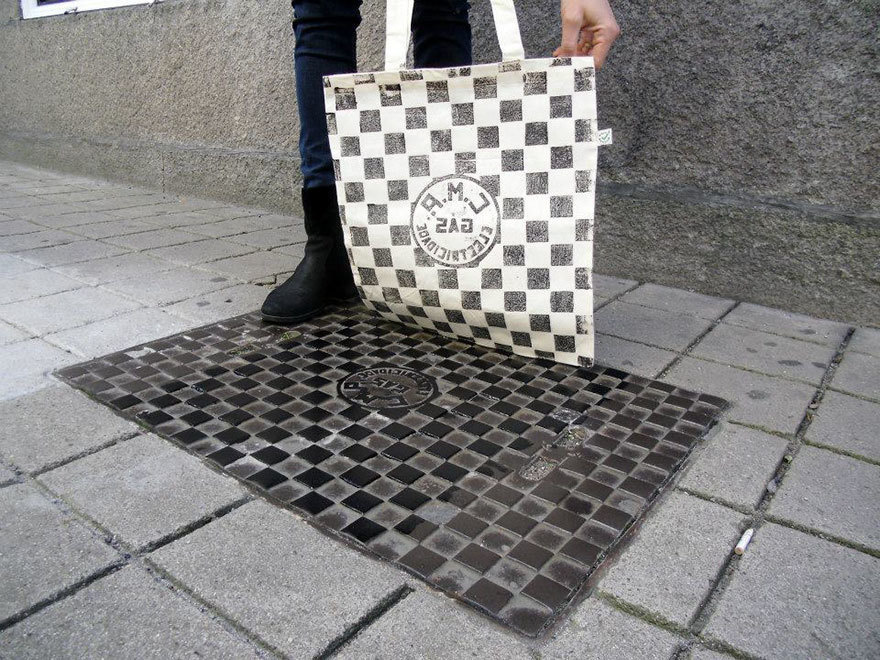 Drain covers are painted with the garment or bag pressed against it, resulting in the print. 