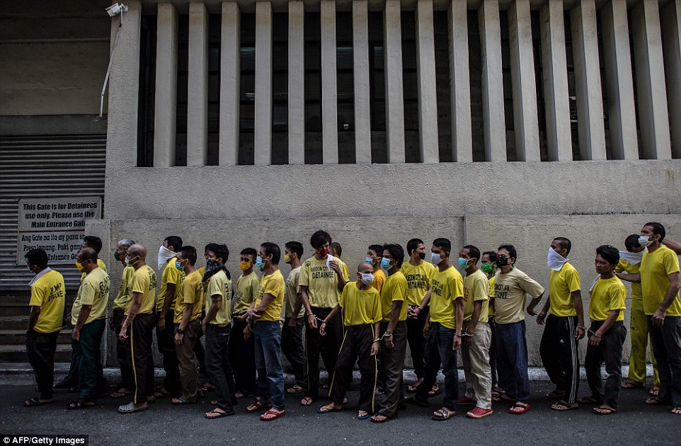 Pictured in their regulation yellow shirts, inmates queue up to attend their trial at the Quezon City regional trial court 