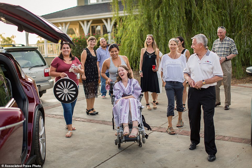 Betsy Davis, center, is accompanied by friends and family for her first ride in a friends new Tesla to a hillside to end her life 