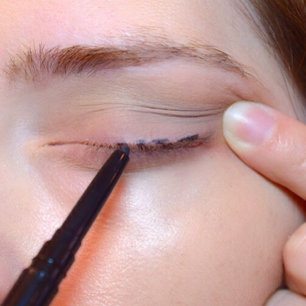 For easy eyeliner application, dot your lashes and connect them with a brush to create an even stroke.