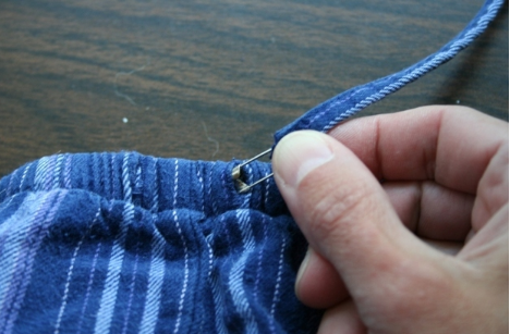 Or attach a safety pin to the end of a rogue drawstring to push it back in place.