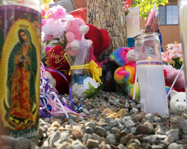 A memorial for a 10-year-old girl who police said was sexually assaulted, strangled then dismembered is seen at an Albuquerque apartment building Thursday