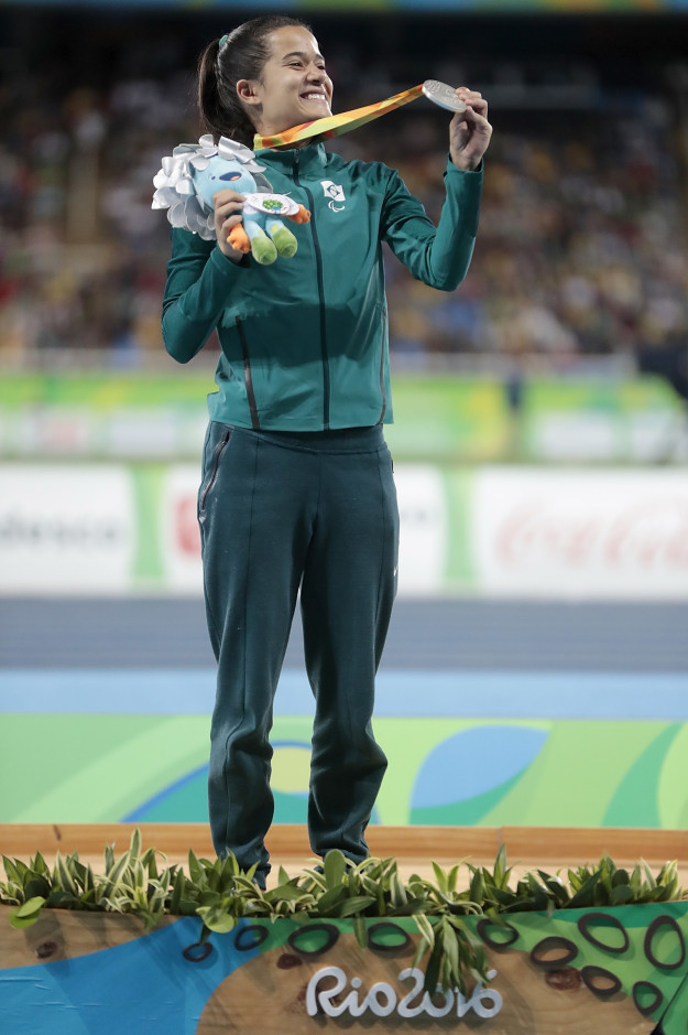 Below, Brazilian Verônica Hipólito clutches her silver-haired Tom doll while showing off her silver medal.