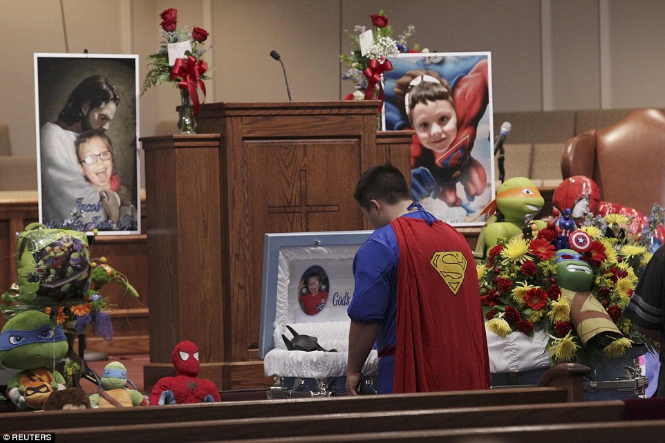 Dale Hall, dressed in a Superman outfit, stands before the casket during the funeral for his brother  Jacob Hall on Wednesday